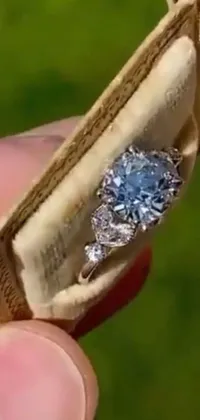 This phone live wallpaper showcases a stunning close-up of a ring in a box