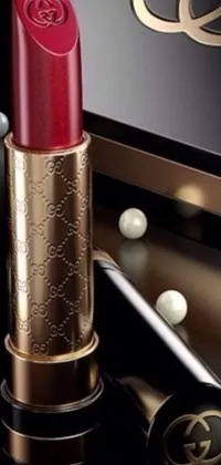 This phone live wallpaper displays a stunning close-up of a lipstick set on a table