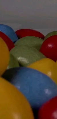 This lively phone live wallpaper showcases a pile of colorful balls crafted from treats such as candy and eggs, sitting atop a table in front of a grainy film footage background