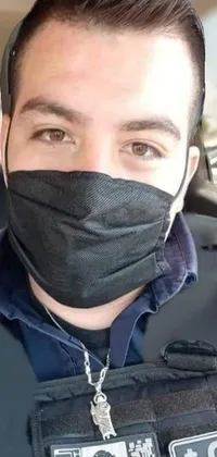 This live wallpaper features a man wearing a face mask and police uniform while sitting in a car