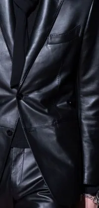 This live phone wallpaper features a closeup of a stylish man wearing a leather suit, walking down a runway