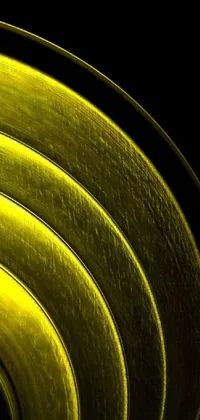 Add a pop of color to your phone with this stunning live wallpaper! Featuring a close-up shot of a circular object in vibrant yellow color, the design showcases a vintage metal appearance with dirt and rust creating a texture in the surface area