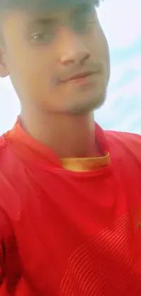 This phone live wallpaper showcases a striking close-up of a person wearing a red shirt against a dark background