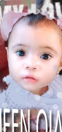 Looking for a charming phone live wallpaper? Look no further than this adorable close-up of a baby girl with a bow on her head