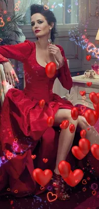 This live wallpaper features a confident woman in a stunning red dress, sitting elegantly on a chair