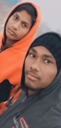 This live wallpaper features two brown-skinned individuals standing side-by-side on a beach