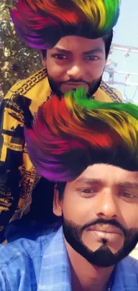 This phone live wallpaper features an eye-catching image of a man riding on the back of another man with colorful half and half hair dye, in a vibrant Indian style