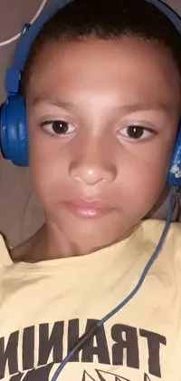 This phone live wallpaper showcases a delightful image of a child wearing headphones