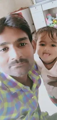 This smartphone live wallpaper depicts a heartwarming scene of a man holding a young child, captured in an 8k front-facing selfie