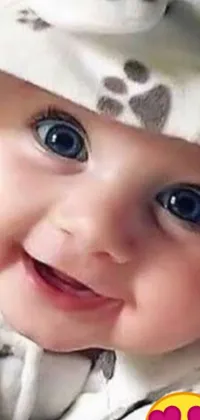 Bring a smile to your face every time you unlock your phone with this Live Wallpaper featuring a close-up image of a happy baby in a hat