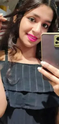 This live wallpaper for your phone showcases an image of a young woman standing in front of a mirror, taking a selfie and wearing a cheerful smile