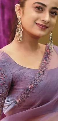 This live phone wallpaper depicts a beautiful woman in a purple sari with intricate patterns