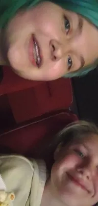 This lively phone live wallpaper showcases a heartwarming photograph of two young women having a great time together at the movies