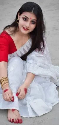 Looking for a stunning live wallpaper for your phone? Look no further than this exquisite depiction of a beautiful Bangladeshi woman dressed in a red and white sari