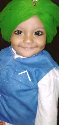This phone live wallpaper features a stunning close-up of a child wearing a green turban and blue traditional clothes, alongside farm attire