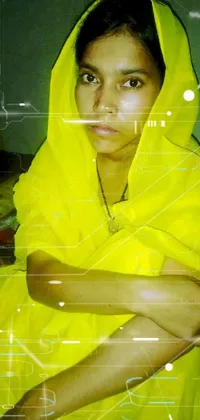 This live phone wallpaper depicts a woman in a yellow dress sitting on a bed, covered with a blanket