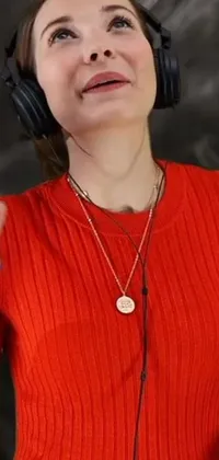 This vibrant live wallpaper showcases a close-up shot of a woman in a red sweater wearing stylish headphones while accessorizing with a gold necklace
