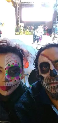 This live wallpaper features two people with painted faces posing for a picture in a colorful and geometric background