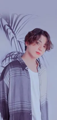 This phone live wallpaper showcases a stunning image of a man standing in front of a tall palm tree, taken by an acclaimed photographer known for their realistic captures on Instagram