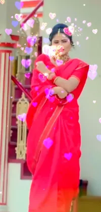 This live phone wallpaper showcases a mesmerizing scene of a woman in a bright red sari blowing bubbles amidst a backdrop of swirling colored bubbles