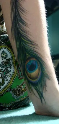 This phone live wallpaper showcases a beautiful peacock feather tattoo on a woman's leg