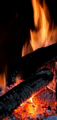 This highly detailed phone live wallpaper captures the warm, flickering light of a burning flame in a fireplace or campfire