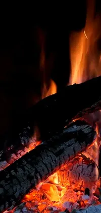 This phone live wallpaper shows a highly detailed, close-up view of a fire in a fireplace