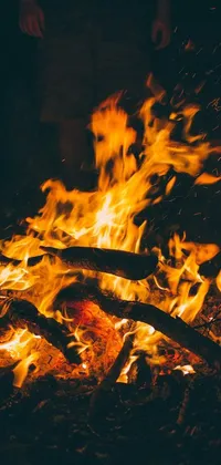 This phone live wallpaper features a serene group gathered around a lively campfire against a natural, striking background