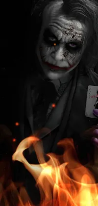 This phone live wallpaper features a menacing man, dressed as a joker, holding a playing card