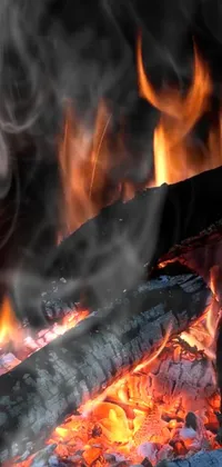 This phone live wallpaper features a close-up of a blazing fire with smoke billowing out of it, lending to a background of chaos magick with the look and feel of a cozy campfire