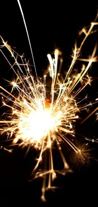 Add a touch of magic to your phone with this stunning live wallpaper featuring a close up of a sparkler burning in the dark