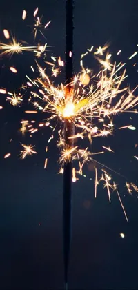 This phone live wallpaper features a stunning sparkler lighting up the dark