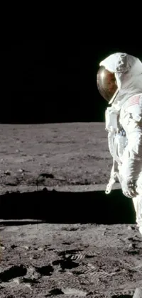 This live phone wallpaper features an awe-inspiring image of an astronaut standing next to an American flag on the surface of the moon