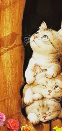 Get this cute and playful live wallpaper for your phone featuring two adorable kittens sitting on a wooden floor surrounded by flowers and greenery