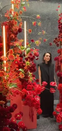 This live phone wallpaper showcases a woman in front of a flower display