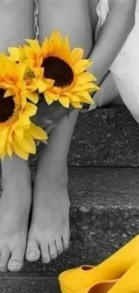This phone live wallpaper features a pair of striking yellow shoes and a vivid bouquet of sunflowers against a black and white photo