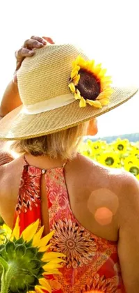 This phone live wallpaper displays a stunning image of a woman standing amidst a field of bright yellow sunflowers