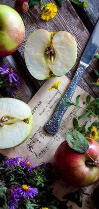 This live wallpaper features a still life scene of apples sitting on a wooden table, surrounded by herbs and flowers, cutlery and magical notes