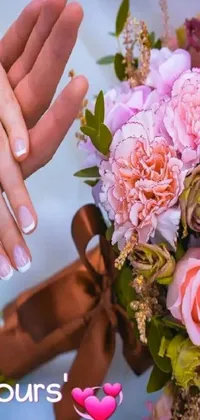 This romantic and beautiful phone live wallpaper depicts a close-up of a bouquet of flowers held by someone's hand