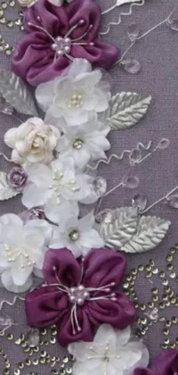 This phone live wallpaper features a close-up of a stunning piece of flower art with intricate details of baroque, satin ribbons, purple crystal inlays, white, silver, and crafts