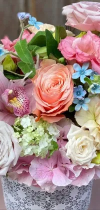 This live phone wallpaper features a charming close-up of a pastel-colored vase of flowers on a table