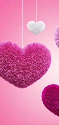 This live wallpaper by Toei Animations features three hearts in different colors hanging from strings against a pink background