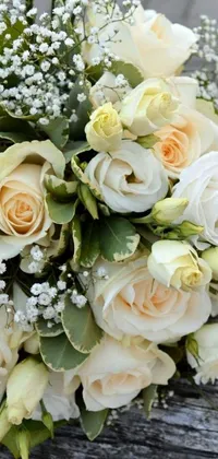 This live wallpaper boasts a stunning bouquet of white and peach roses, with delicate baby's breath flowers, seated upon a rustic wooden bench