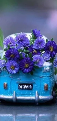 This phone live wallpaper showcases a charming blue car with a hippie aesthetic complete with purple flowers on top