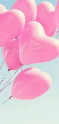 This live wallpaper features a romantic and charming design of pink heart-shaped balloons floating peacefully through a blue sky