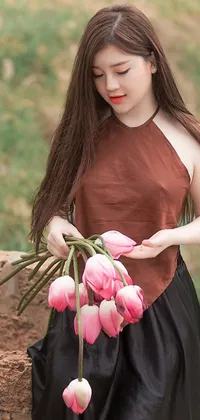 This stunning live wallpaper depicts a woman holding a bunch of pink tulips in a nature-inspired al fresco setting