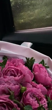 This live wallpaper features a beautiful pink floral arrangement sitting in a car
