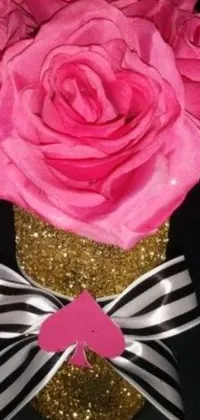 This stunning live phone wallpaper showcases a beautiful vase filled with pink roses atop a sophisticated black and gold table