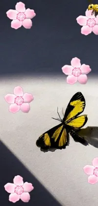 This phone live wallpaper features a yellow and black butterfly hovering over pink flowers