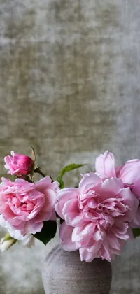 This phone live wallpaper is the epitome of natural beauty, featuring a pink flower-filled vase sitting on a table